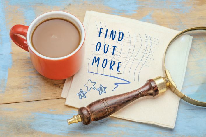 Coffee cup and magnifying glass with prompt 'Find out more' about flexible English Language Learning on a scrap of notepaper